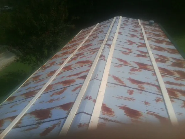 Rusted metal roof panels with new wood purlins before replacement — Storm Damage Roof Repair in Vandiver by Roofing Brothers