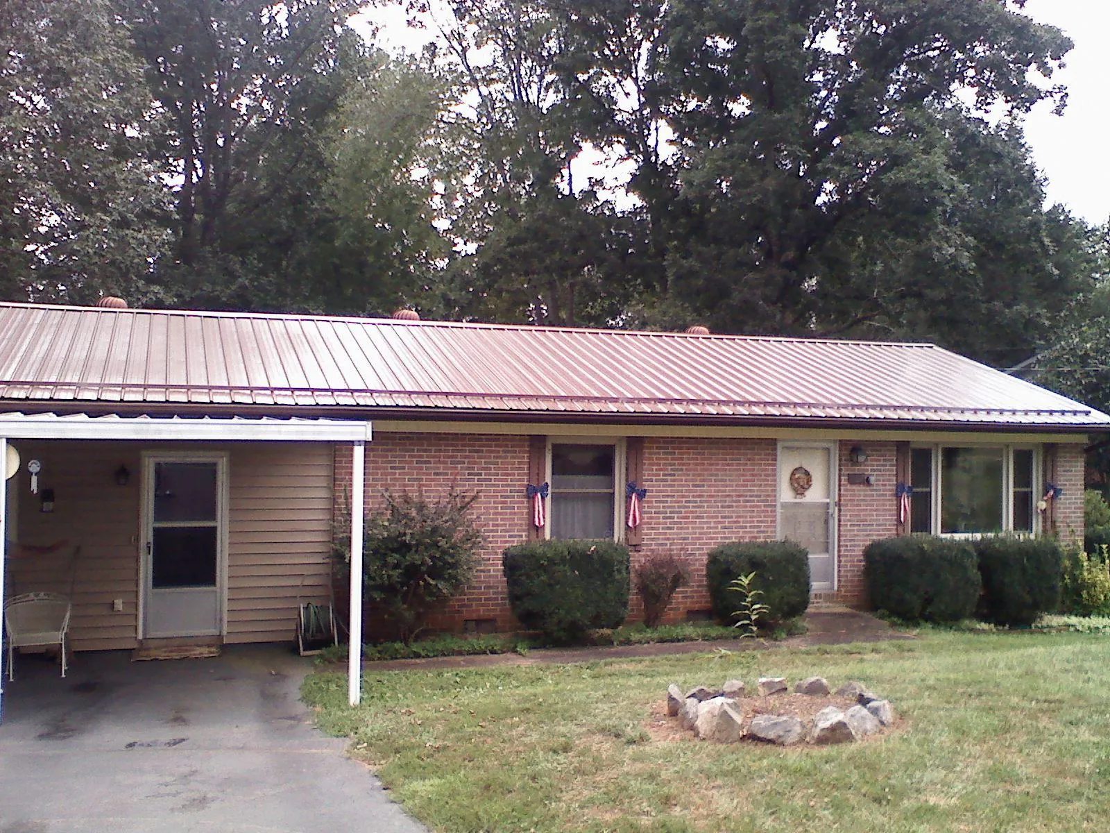 Bronze metal roof and carport on a brick ranch home — Roof Repair work by our crew in Vandiver