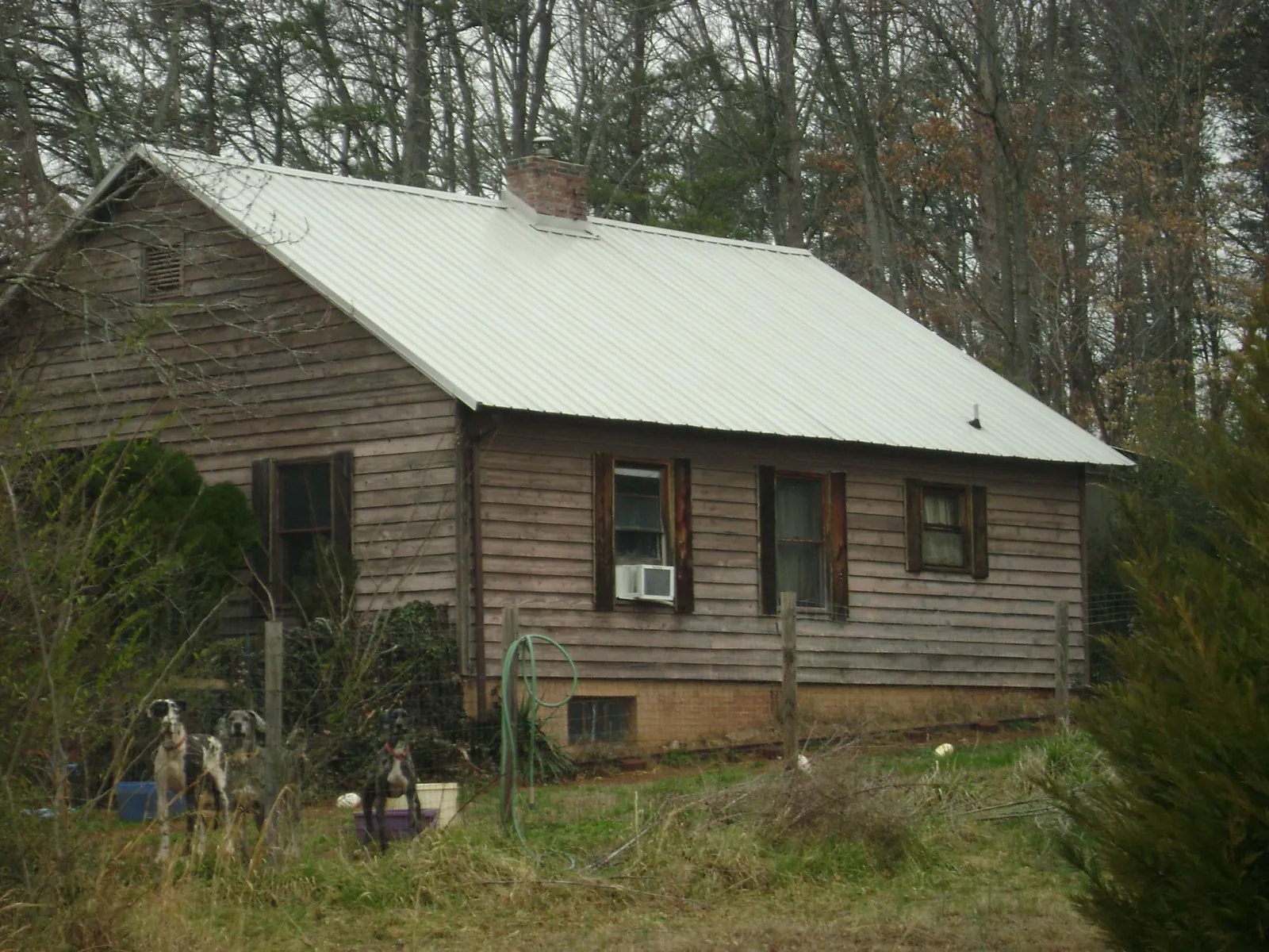 White metal roof on an old wood sided farmhouse, from a Metal Roof Installation job in Vandiver